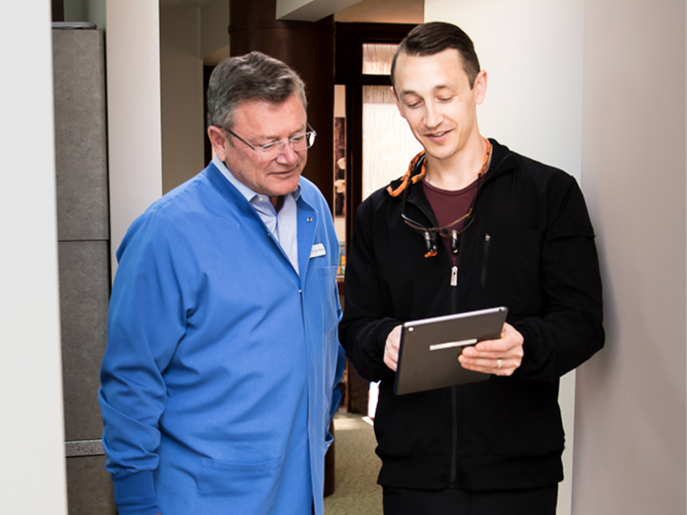 Dr. Nick & Stuart looking at an iPad together in the hallway